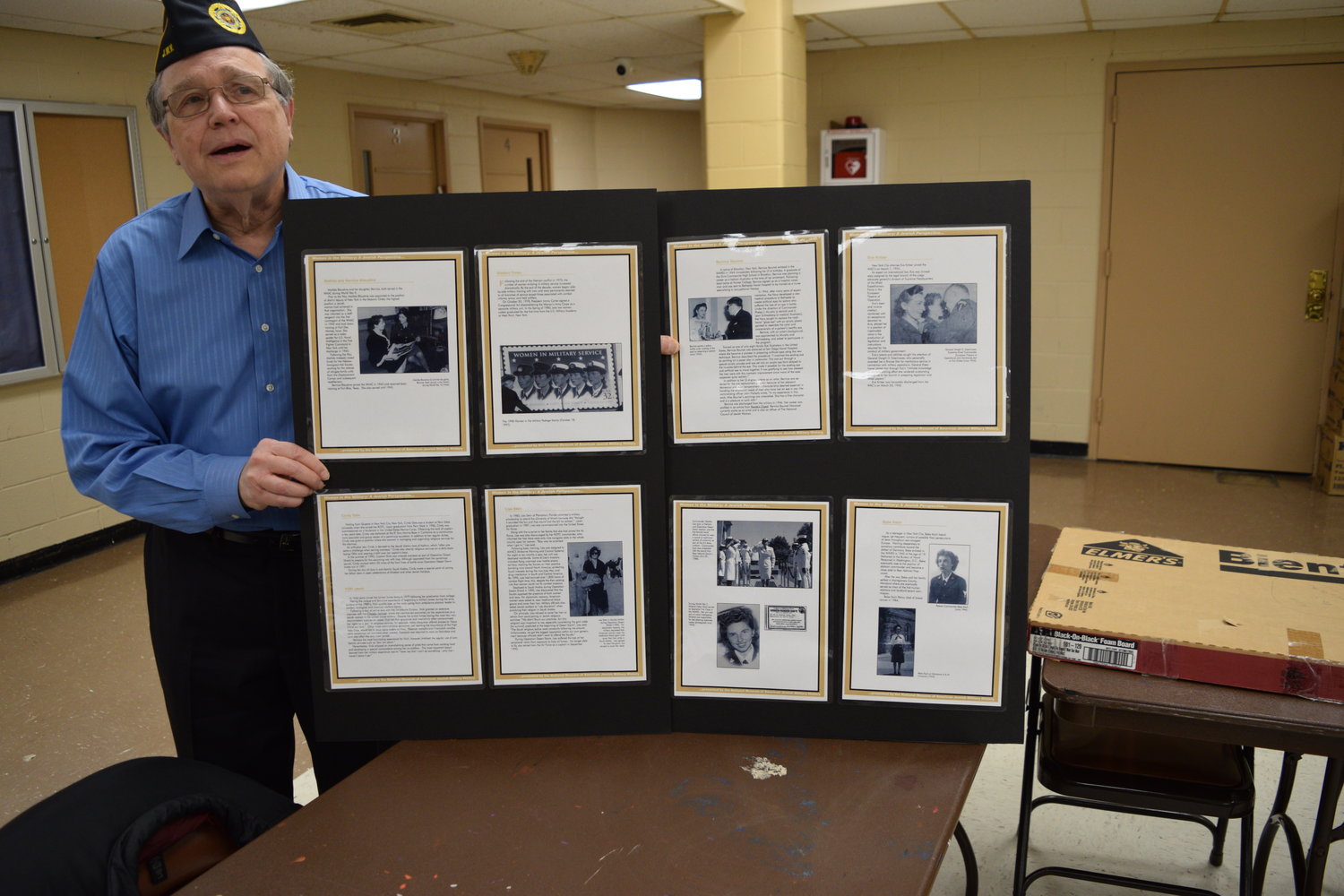 Ed Freeberg, a U.S. Air Force veteran, displays posters from the "Women in the Military" collection  honoring those Jewish women who served in the U.S. Armed forces.